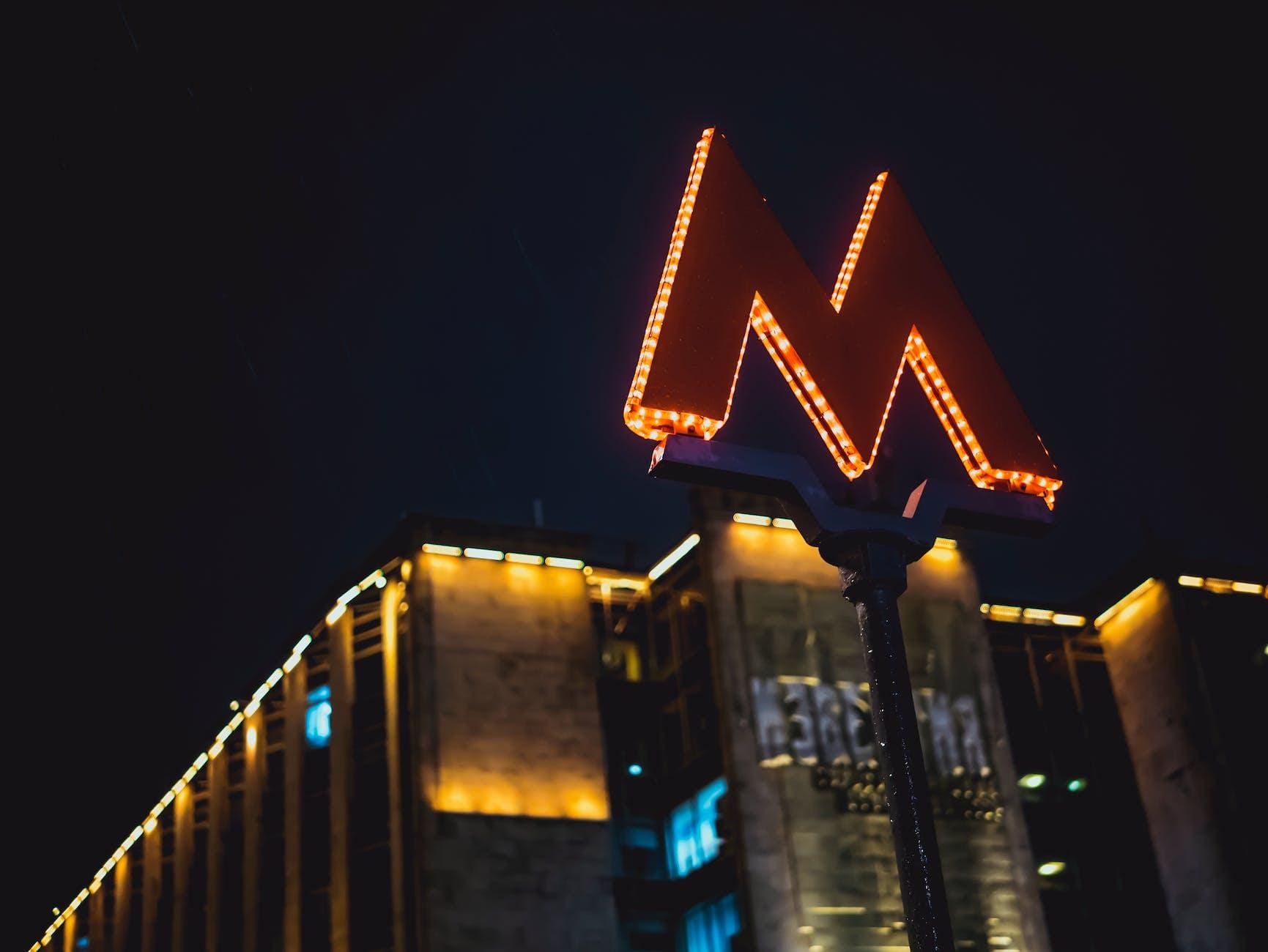 low angle photography of lighted m road sign during nighttime